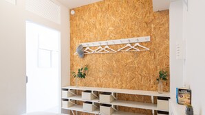 Un dormitorio con pared de madera, una cama blanca, un estante blanco y un libro en el estante.