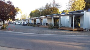 Una hilera de casas móviles modernas con zonas de estar al aire libre y paneles solares en los techos.