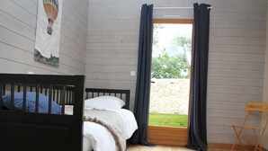 A bedroom with a bed, a small table, and a window with curtains. - The closed Hellen .... (monterblanc)