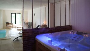 A spa area with a hot tub, a small seating area with chairs, and a large window. - The closed Hellen .... (monterblanc)