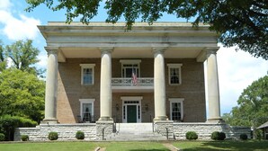 A two-story brick building with a central entrance flanked by columns, a balcony with railings, and a flagpole. - PERFECT LISTING !!! House in Historic Chickamauga (Chickamauga)