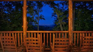 A wooden deck with chairs facing a scenic overlook. - Family Adventure Cabin | Large theater | Views (Sevierville)