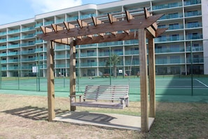 Situated beneath a simple pergola, this serene outdoor space invites relaxation.