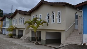 A row of residential buildings with uniform architecture, featuring multiple windows and a central staircase.