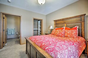 Ein Schlafzimmer mit einem großen Bett, einem Holzkopfteil und einem begehbaren Kleiderschrank.