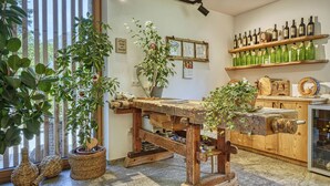 Eine rustikale Küche mit Holztisch, Topfpflanzen und einem Weinregal.