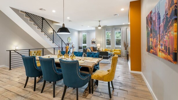 Un intérieur moderne comprenant un coin repas, un escalier et un grand tableau.