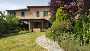 A brick house with a covered patio, stone pathway, and lush greenery. - THE FRANCIGENA TWO-ROOM CUSTOMS (Siena)