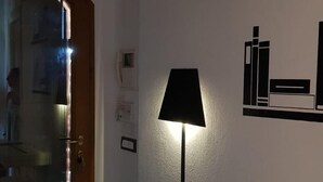 A room with a wooden door, a white desk, a lamp, and a wall with black book illustrations. - THE FRANCIGENA TWO-ROOM CUSTOMS (Siena)