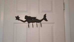 A white door with a black fish-shaped coat hook.