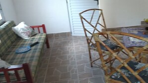 Un coin repas avec une table ronde, des chaises, un tapis à motifs et une plante en pot.