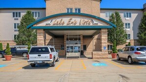 L’entrée d’un hôtel, avec une enseigne indiquant « Vue sur le lac Érié ». On y voit deux places de stationnement signalées par le symbole d’un fauteuil roulant, et un camion Chevrolet est garé au premier plan.