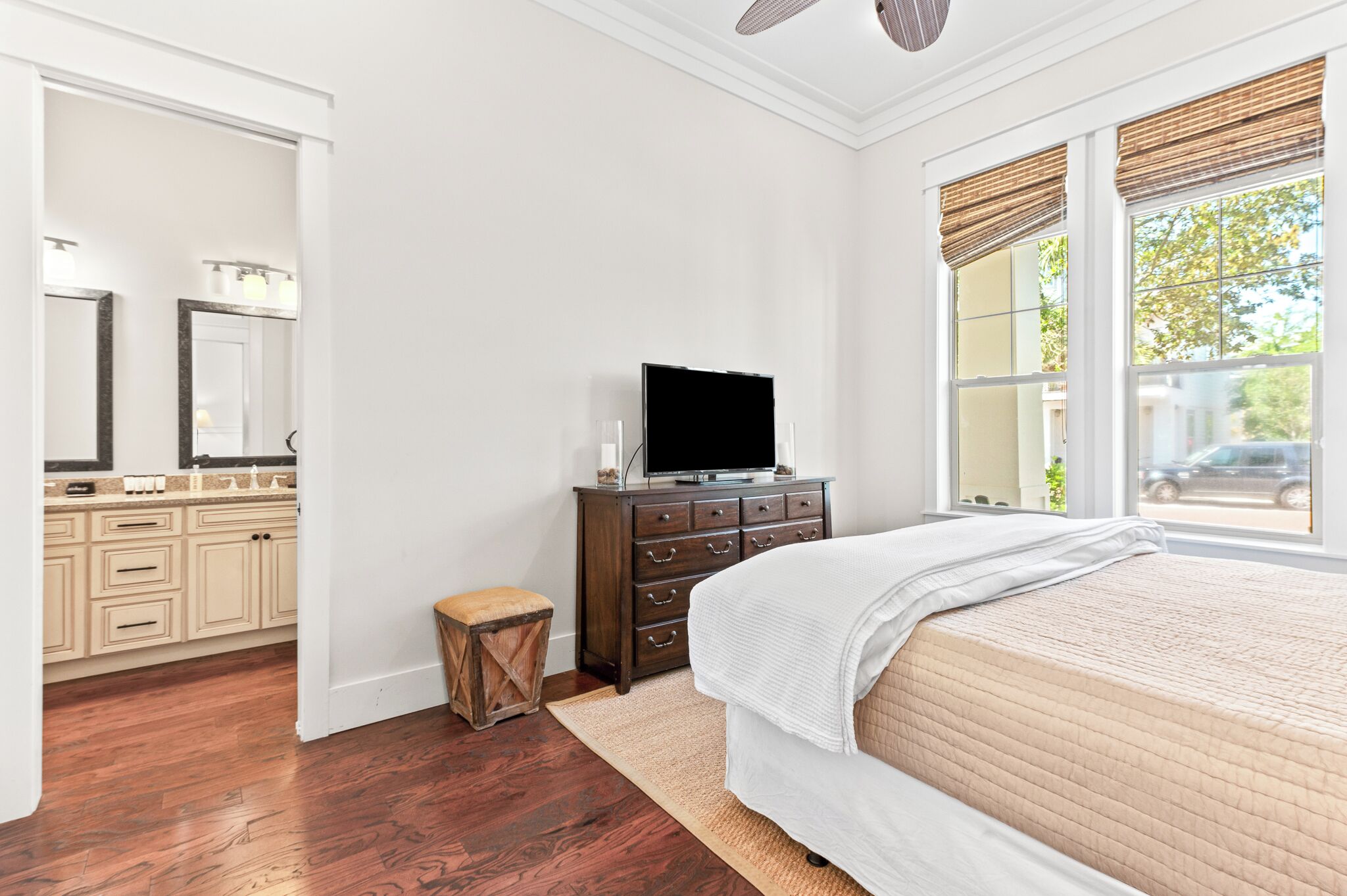 Un dormitorio con cama, cómoda, tocador y televisor.