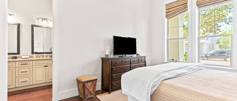 Un dormitorio con cama, cómoda, tocador y televisor.