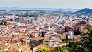 Un área urbana densamente poblada con una mezcla de edificios residenciales y comerciales, que presenta una variedad de estilos arquitectónicos y un telón de fondo montañoso.