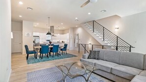 A modern apartment with a dining area, kitchen, living room, and a staircase. - 3-Level Brand New Townhouse in Mid City (New Orleans)