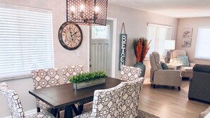 A dining area with a dark wooden table, patterned chairs, and a decorative centerpiece. - Charming Bungalow, remodeled, heated pool, walk to the beach (Naples)