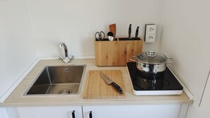 Kjøleskap, mikrobølgeovn, kjøkkenutstyr og papirhåndklær