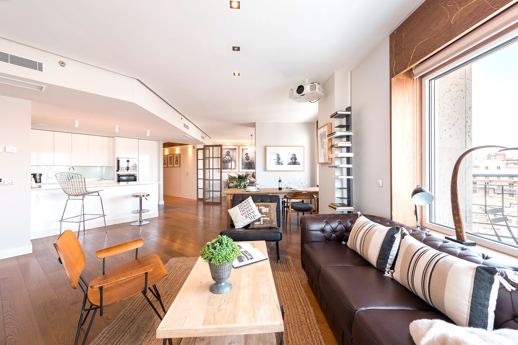 Un salon moderne comprenant un canapé, un coin repas et une cuisine.