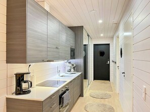 A modern kitchen with a built-in oven, a coffee machine, and a large mirror above the counter. - Kasnäs marina b 15 by Interhome (Kemiönsaari)