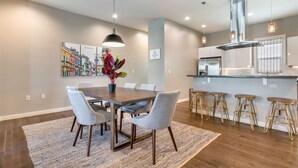A modern kitchen with stainless steel appliances, a central island, and bar stools.