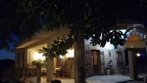 A stone building with a covered patio area, columns, and a lantern.
