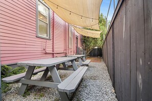 A picnic table set up in a backyard with a house in the background.