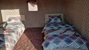 Une chambre avec deux lits, de la literie à motifs et un sol à motifs.