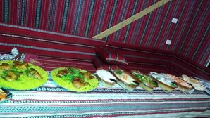 Une table de buffet garnie de différents plats et recouverte d’une nappe à motifs.