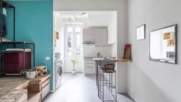 Enjoy a cozy seating space with a wooden bench and table, plus a fully equipped kitchen and laundry facilities.