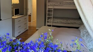 A bedroom with a bunk bed, a bedside table with a lamp, a wardrobe, and a door leading to another room. - STELLA DELLE GRIGNE (Pasturo)