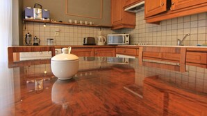 Cozinha com armários de madeira, micro-ondas e cafeteira.