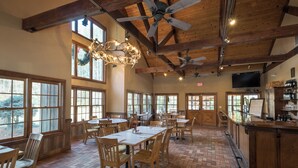 A spacious dining area with high ceilings, large windows, and a variety of seating arrangements. - Pet-Friendly,Cozy Cabin,Hot Tub,Wood Fireplace,WiFi (Ferguson)