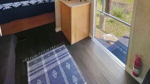 A bedroom with a bed, a small desk, a window, and a view of greenery outside. - Blissful RV Retreat in Canyon Lake! Only 5 minutes from the lake and river! (Canyon Lake)