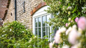 Un bâtiment en pierre avec une fenêtre blanche et un arc en briques.