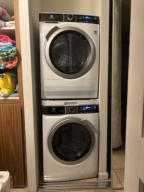 A stacked washer and dryer unit in a laundry room. - View Beachfront, Turtles, swim snorkel sun. AC Free parking Washer dryer. (Hauula)