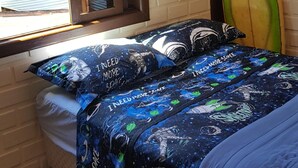 A bedroom with a bed, a window, and a surfboard against the wall. - Casa do Sassá - Close to everything (Guarda do Embaú)