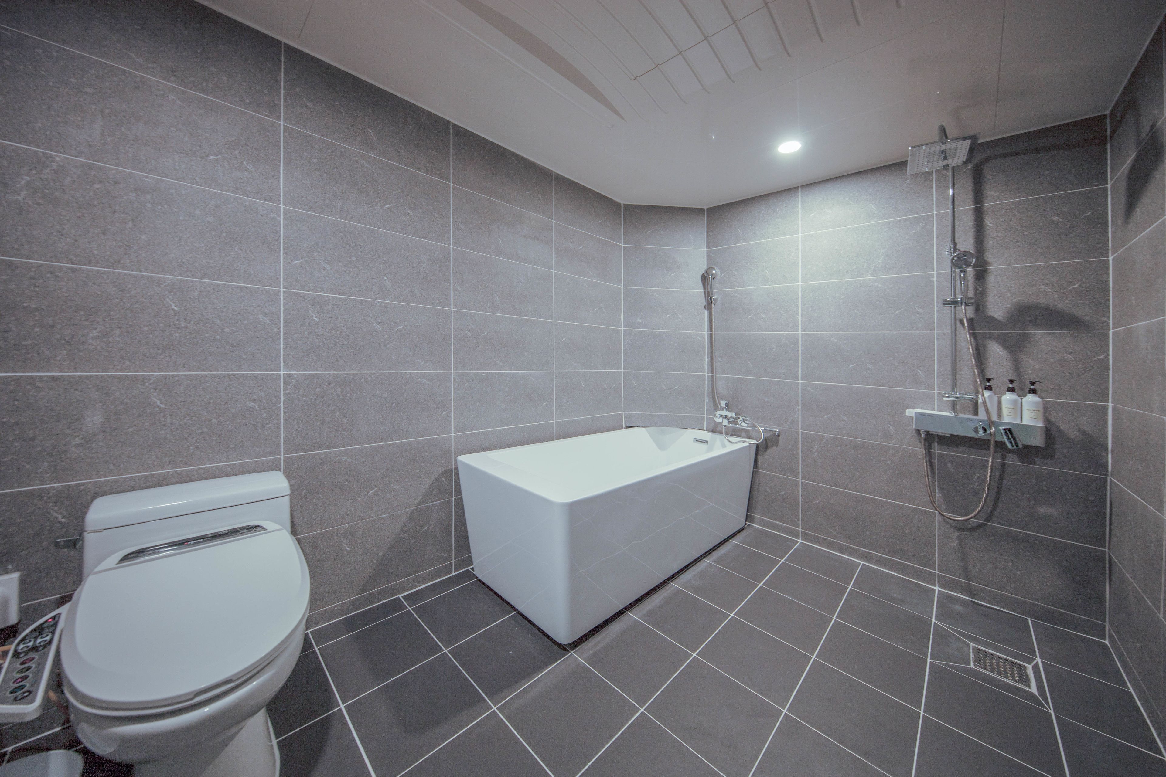 deluxe king room | bathroom | separate bathtub and shower, deep-soaking bathtub, designer toiletries