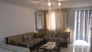 Uma sala de estar com sofá, mesa de centro e mesa de jantar.