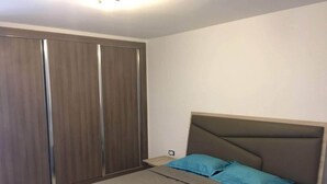 Um quarto com uma cama, um guarda-roupa e uma mesa de cabeceira.