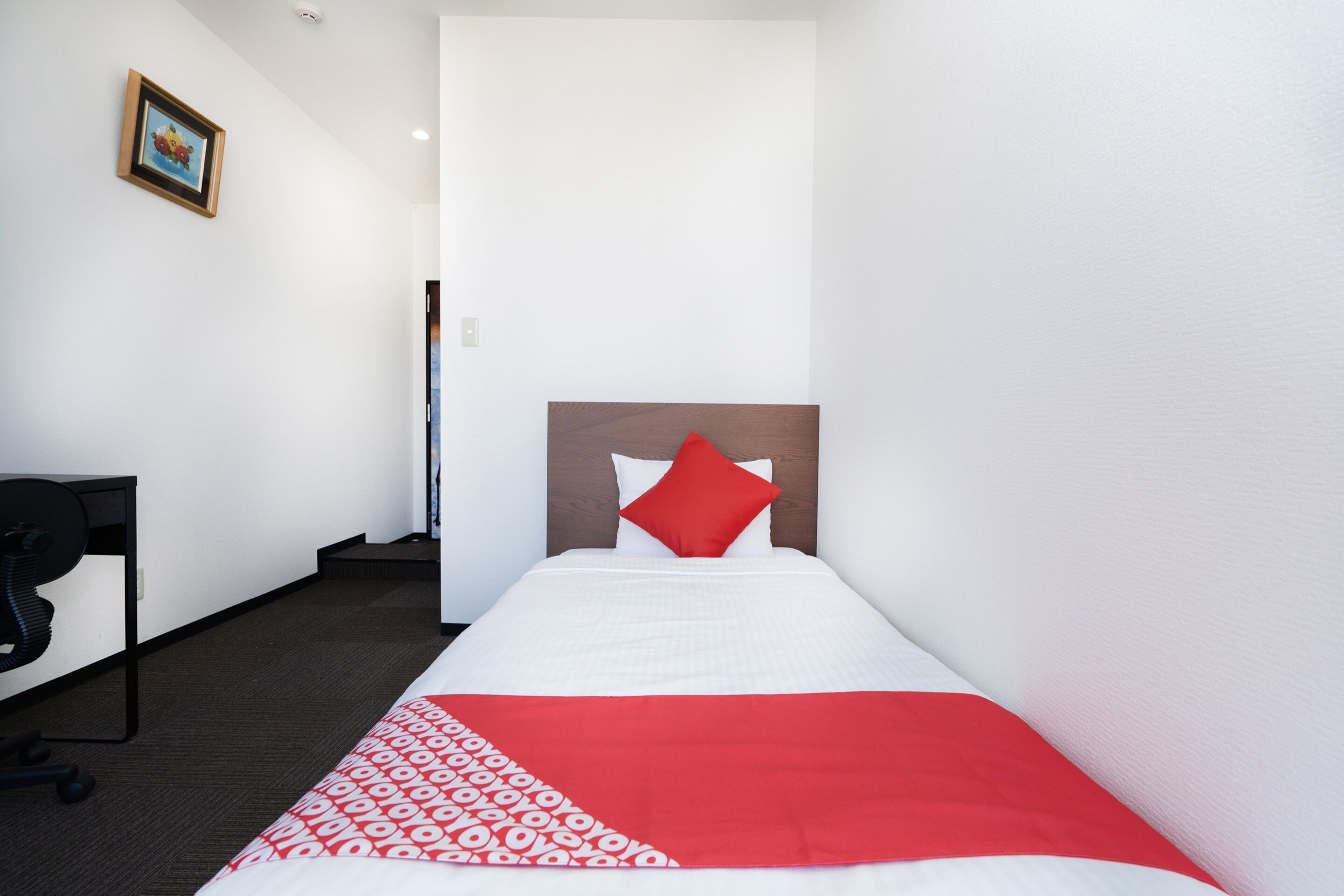 Una habitación de hotel con una cama, un escritorio y una silla.