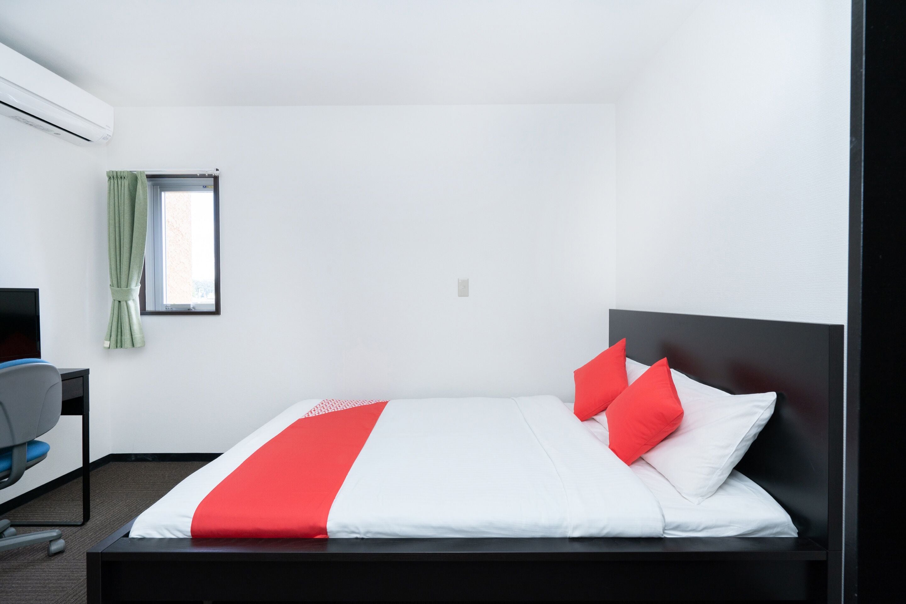 Una habitación de hotel con una cama, un escritorio y una silla.