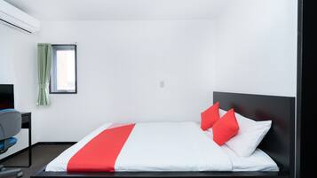 Una habitación de hotel con una cama, un escritorio y una silla.