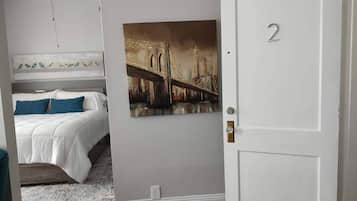 Un dormitorio con una cama, un cuadro de un puente y una puerta con el número 2.