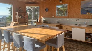 Una cocina moderna con vigas de madera, una isla grande y vistas al exterior.