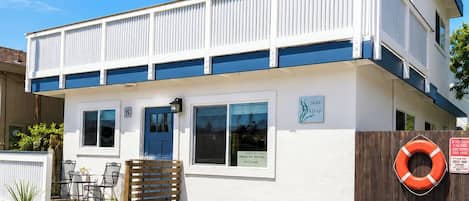 A two-story building with a sign indicating it is a vacation rental.