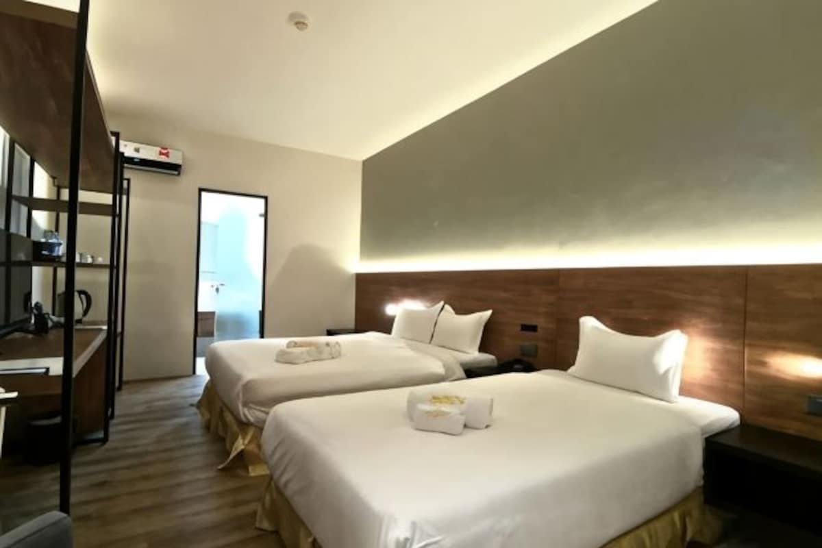 Ett hotellrum med två sängar, ett skrivbord och en garderob.
