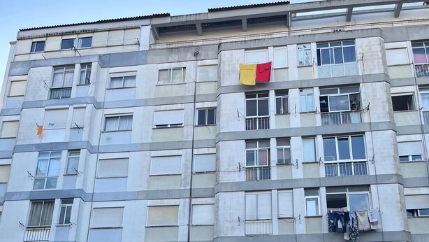 Un edificio residenziale a più piani con balconi, finestre e biancheria stesa.