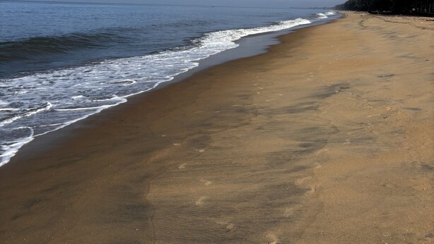 A beach with a clear sky and calm sea.