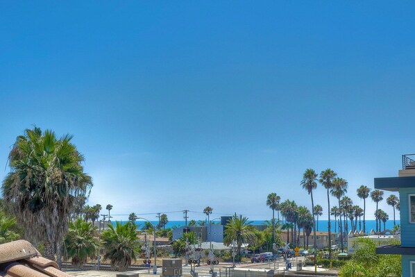 A coastal area with palm trees, a beach, and a train crossing. - Massive Ocean View Rooftop - 4 Min Walk to Beach (Oceanside)